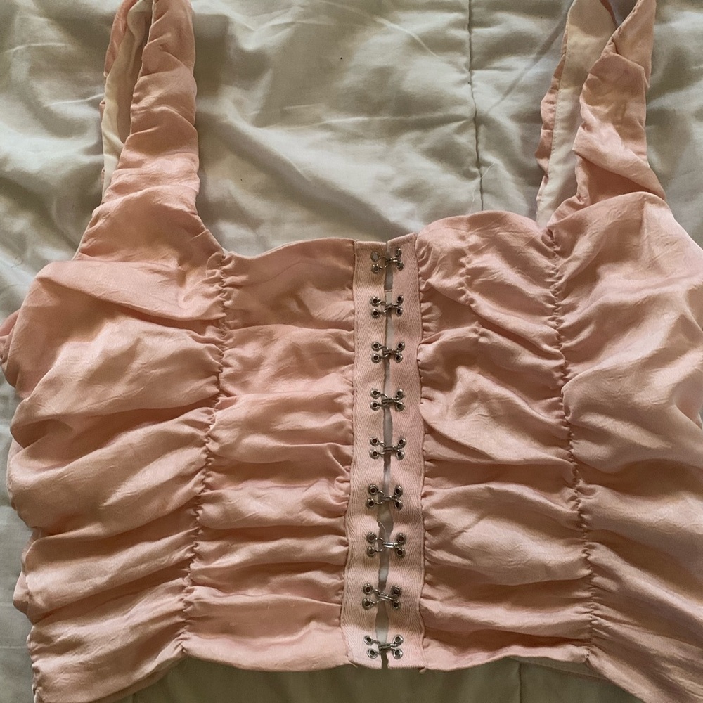 Soft pink ruffle-pattern crop top.